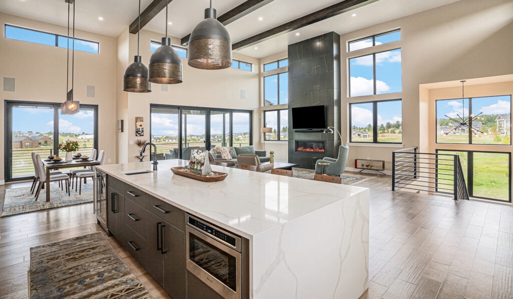 Modern luxury kitchen and living space with a fireplace, large balcony, abundant natural light, and a formal dining area.