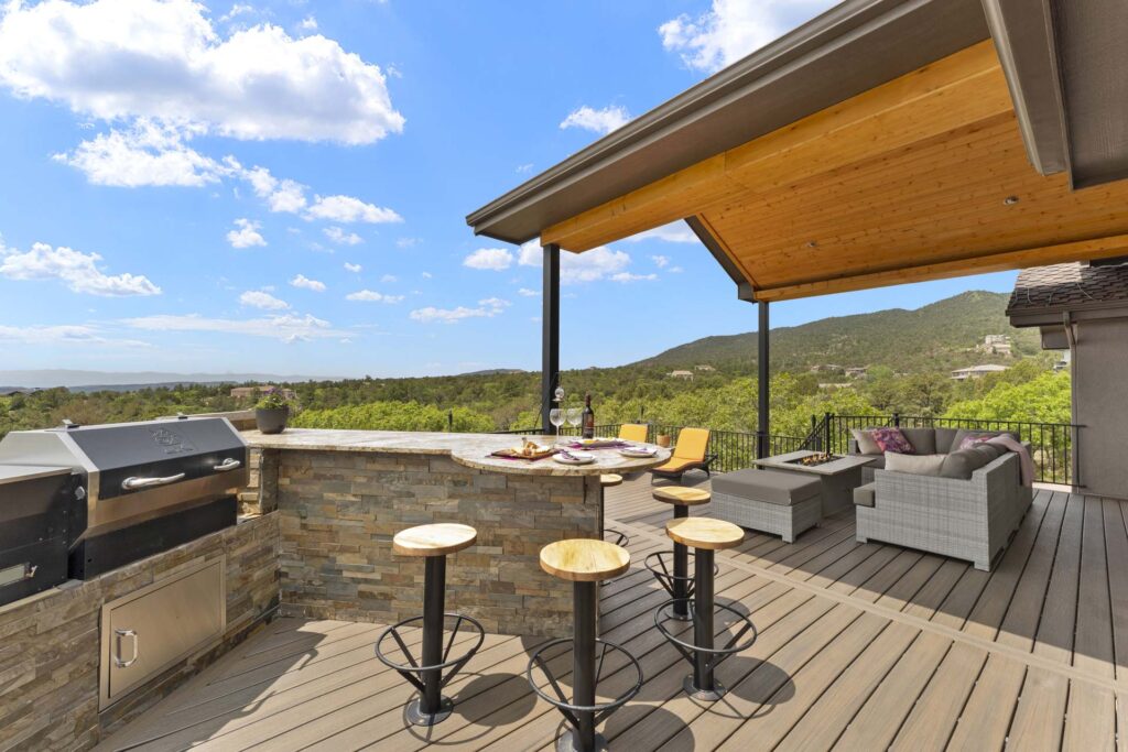 HDR Real Estate Photograph of a large outdoor deck and fireplace with mountain views