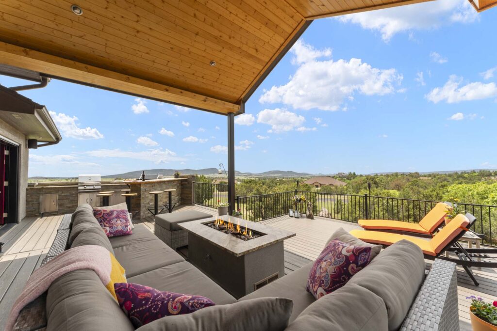 HDR Real Estate Photograph of a large outdoor deck and fireplace with mountain views