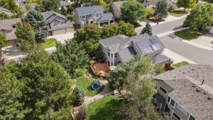 Drone image of a large home in Denver with a backyard deck on a corner lot.