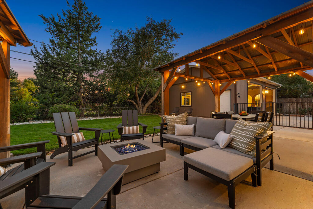 Twilight image of a Denver backyard with fire pit and chairs