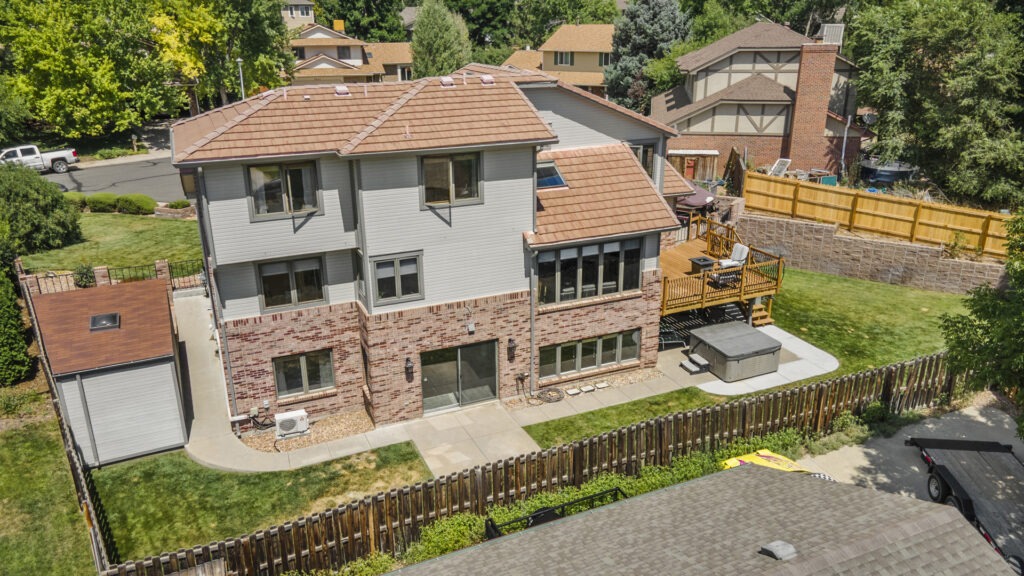 Drone photo of a modern home in Parker with large deck and hot tub